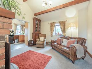 a living room with a brown leather couch at Beckside in Gilcrux