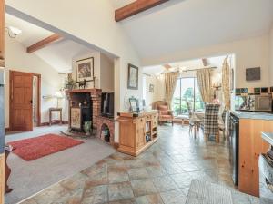 a living room with a fireplace and a table at Beckside in Gilcrux