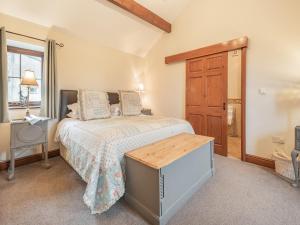 a bedroom with a bed and a wooden door at Beckside in Gilcrux +13 photos