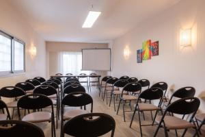 a room with rows of chairs and a whiteboard at Hôtel L'Empreinte in Cagnes-sur-Mer