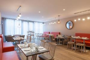 a restaurant with tables and chairs in a room at Hôtel L'Empreinte in Cagnes-sur-Mer