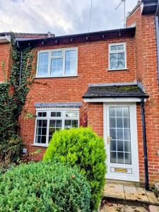 a red brick house with a white door at Central modern home with parking in Nantwich