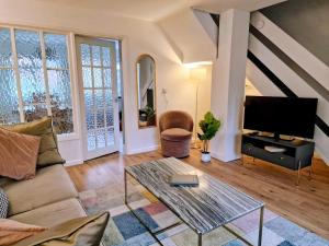 a living room with a couch and a tv at Central modern home with parking in Nantwich