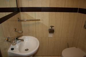 La salle de bains est pourvue d'un lavabo et de toilettes. dans l'établissement Hotel 7, à Szczecin