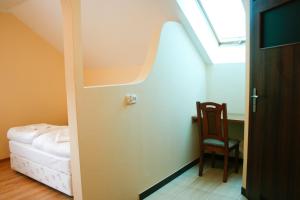 Cette chambre comprend un lit, une chaise et une fenêtre. dans l'établissement Hotel 7, à Szczecin