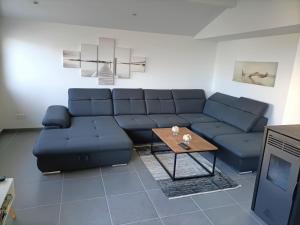 a living room with a blue couch and a table at villa l atlantide in Vieux-Boucau-les-Bains