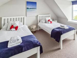 a bedroom with two beds with towels on them at The Shore in Fortrose