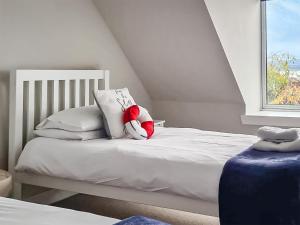 a white bed with a red stuffed animal on it at The Shore in Fortrose +10 photos