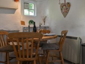 a dining room table with chairs and wine glasses at Horseshoe Cottage in Starbotton