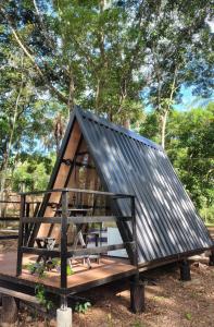 a small house with a metal roof on a wooden platform at Cantinho do Chalé in Jaboticatubas