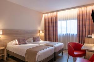 a hotel room with two beds and a red chair at Hôtel L'Empreinte in Cagnes-sur-Mer +41 photos
