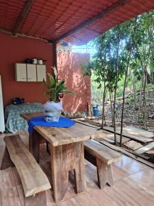 a wooden table and benches in a room at Cantinho do Chalé in Jaboticatubas