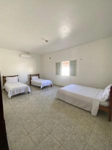 a bedroom with two beds and a window at Casa Jabuticabeira in Manhã