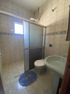a bathroom with a shower and a toilet and a sink at Casa Jabuticabeira in Manhã