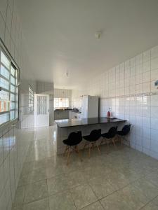 a kitchen with a counter and chairs in a room at Casa Jabuticabeira in Manhã +4 photos