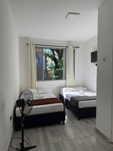 a bedroom with two beds and a window at HOTEL PUERTO DULCE - La Virginia in La Virginia