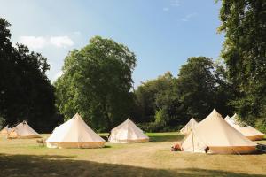 a group of tents in a field with trees at Festival Glamping At The Drum - Glamping Village in Edinburgh