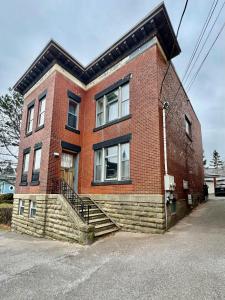 a red brick building with stairs on a street at The Sealy Residence in Saint John