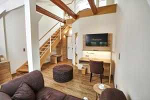 a living room with a couch and a tv at Lounge-Hotel Seeterrassen in Wandlitz
