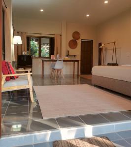 a living room with a bed and a table at Wichouda Cottage - Self Check-in in Chiang Dao