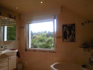 a bathroom with a window and a tub and a sink at Villa Daheim in Bad Rothenfelde
