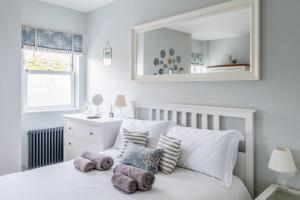 a bedroom with a white bed with pillows on it at Danes House 4 in Aldeburgh