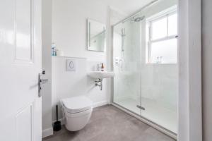 a white bathroom with a toilet and a sink at Danes House 4 in Aldeburgh +31 photos