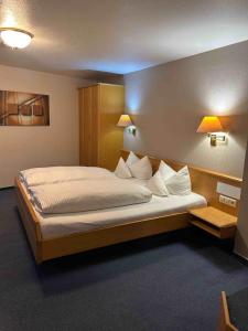 a bedroom with a large bed with white pillows at Hotel Adler in Waiblingen