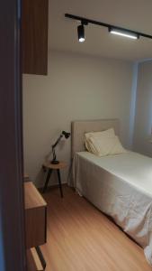 a bedroom with a bed and a lamp on a table at 098house in São Luís +10 photos