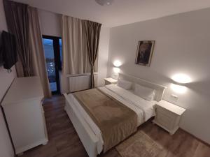 a bedroom with a bed with two night stands and a window at Casa Ovidiu Rasnov in Râşnov