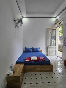 a bedroom with a blue bed in a room at Quốc Hưng in Ấp Trà Cô