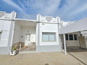 a white house with a patio in front of it at Blife Montya private rooms in Faro +22 photos