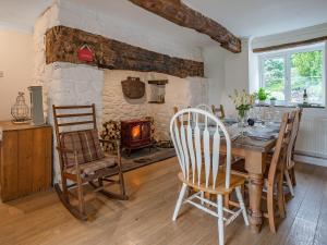 a dining room with a table and chairs and a fireplace at Taliaris Isaf in Llandeilo
