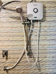 a hair dryer hanging on a wall with a hair brush at Tehan Homestay in Hiriketiya
