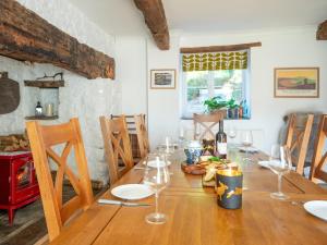 a dining room with a wooden table with wine glasses at Taliaris Isaf in Llandeilo