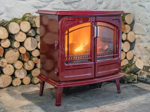 a red stove sitting next to a pile of logs at Taliaris Isaf in Llandeilo +26 photos