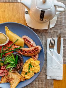 a blue plate of breakfast food with eggs bacon and toast at Apartamenty Gołębia 3 in Krakow