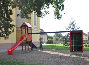 a playground with a slide in front of a building at MAMRE Szálló in Hajdúböszörmény
