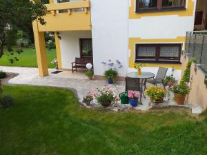 a patio with a table and flowers in a yard at Ferienwohnung Leicht in Heiligenstadt