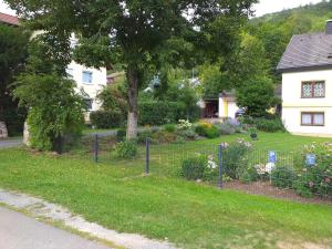 a fence in front of a yard with flowers at Ferienwohnung Leicht in Heiligenstadt