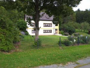 a fence in front of a house with a tree at Ferienwohnung Leicht in Heiligenstadt +28 photos