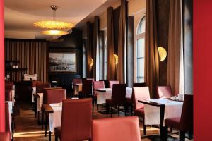 a dining room with tables and chairs and a chandelier at Hotel Alte Post in Konstanz