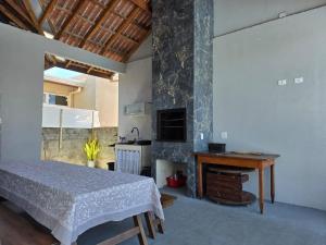 a bedroom with a bed and a table and a stove at Casa com piscina Itapoá Itapema do Norte in Itapoa
