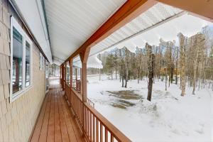 a balcony of a house with snow on the ground at Owls' Hollow in West Dover