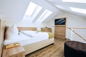 a bedroom with a large bed and a tv at Lounge-Hotel Seeterrassen in Wandlitz