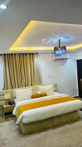 a bedroom with a large bed and a chandelier at HomeWorth Hotel in Efiran