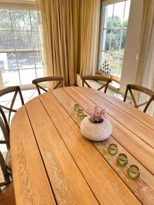 a wooden table with a vase of flowers on it at Z' Evita in Nieuwpoort