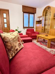 a living room with a red couch and a table at Incentro in Grosio +14 photos
