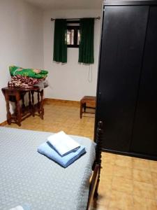 a room with a bed and a black refrigerator at Moradia Lili in Ronqueira +16 photos