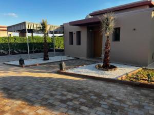 a house with two palm trees in front of it at Palms Edge Villas avec Piscine & Jardin Privés in Marrakesh